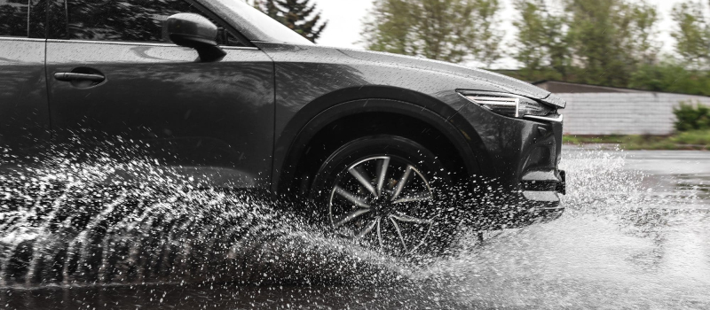 Modern car driving outdoors on rainy day